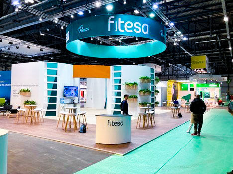 Fitesa trade show booth featuring a circular hanging sign, modern seating, and open layout designed for high-traffic exhibits