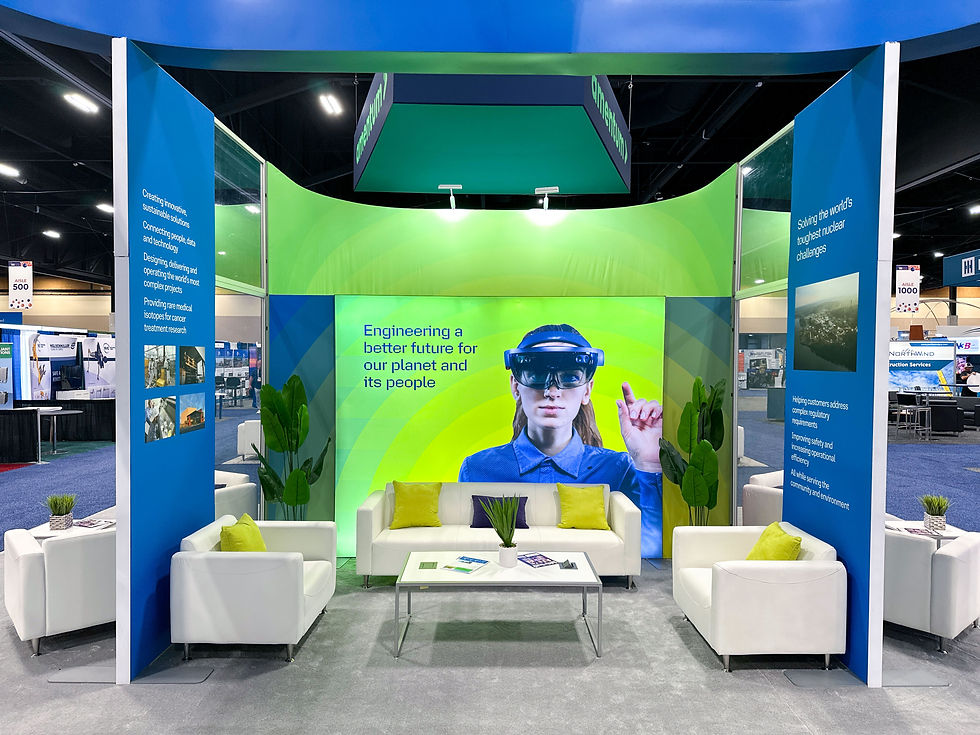 Modern trade show booth with immersive graphic wall, seating lounge, bold branding, and overhead structure designed by Skyline