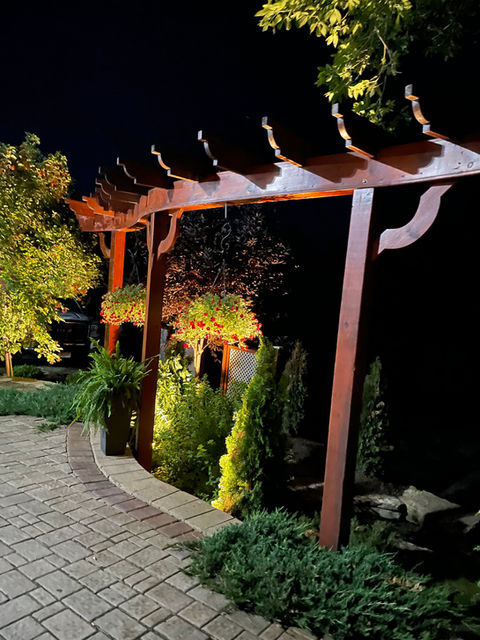 Charming wooden pergola surrounded by plants on a walkway - Marvin's Brick Pavers, Madison, WI