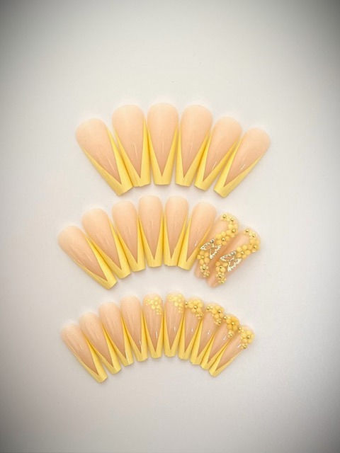 The Belle set features pale yellow V-French tips with 3D flower and butterfly accent nails
