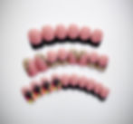 The Goldie set features black french tips, gold glitter accent nails and a pop of pink and yellow