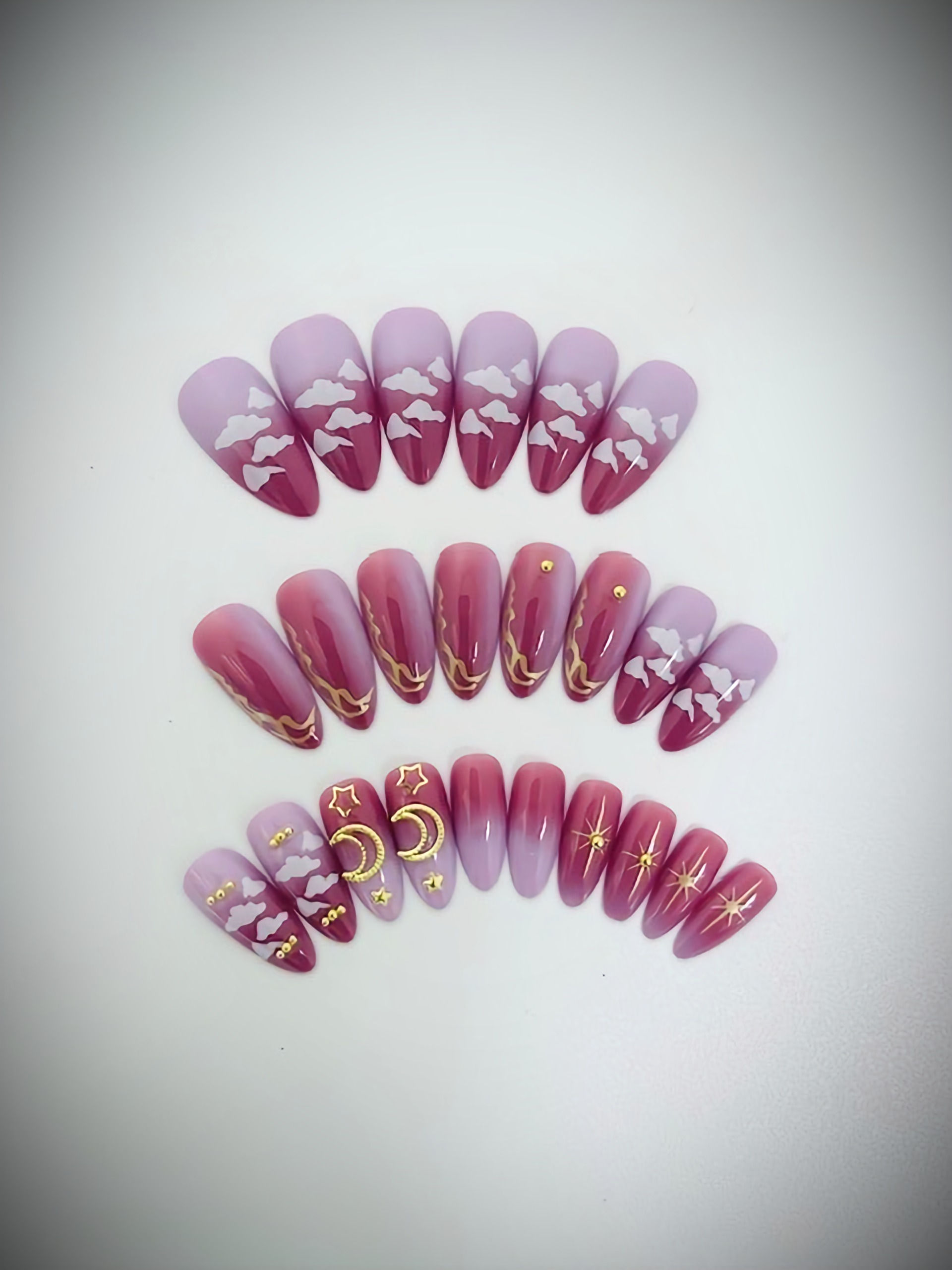 The Celeste set features a lilac and blush mauve ombre design adorned with gold wavy line designs, moons and stars