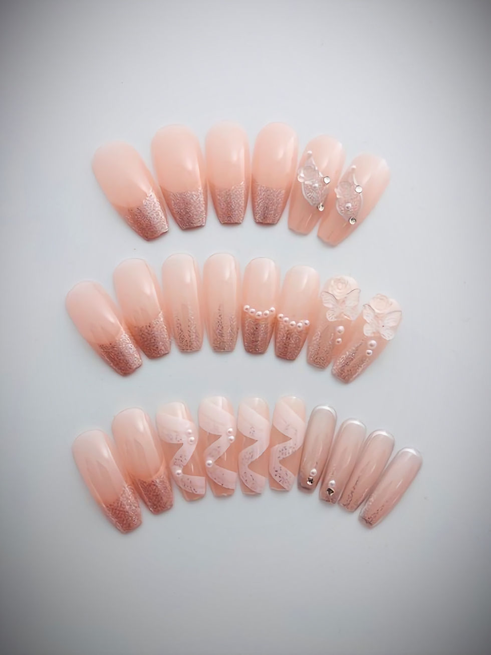 Tory features a transparent peachy pink base with a beige French tip overlayed with silver glitter and stunning accent nails