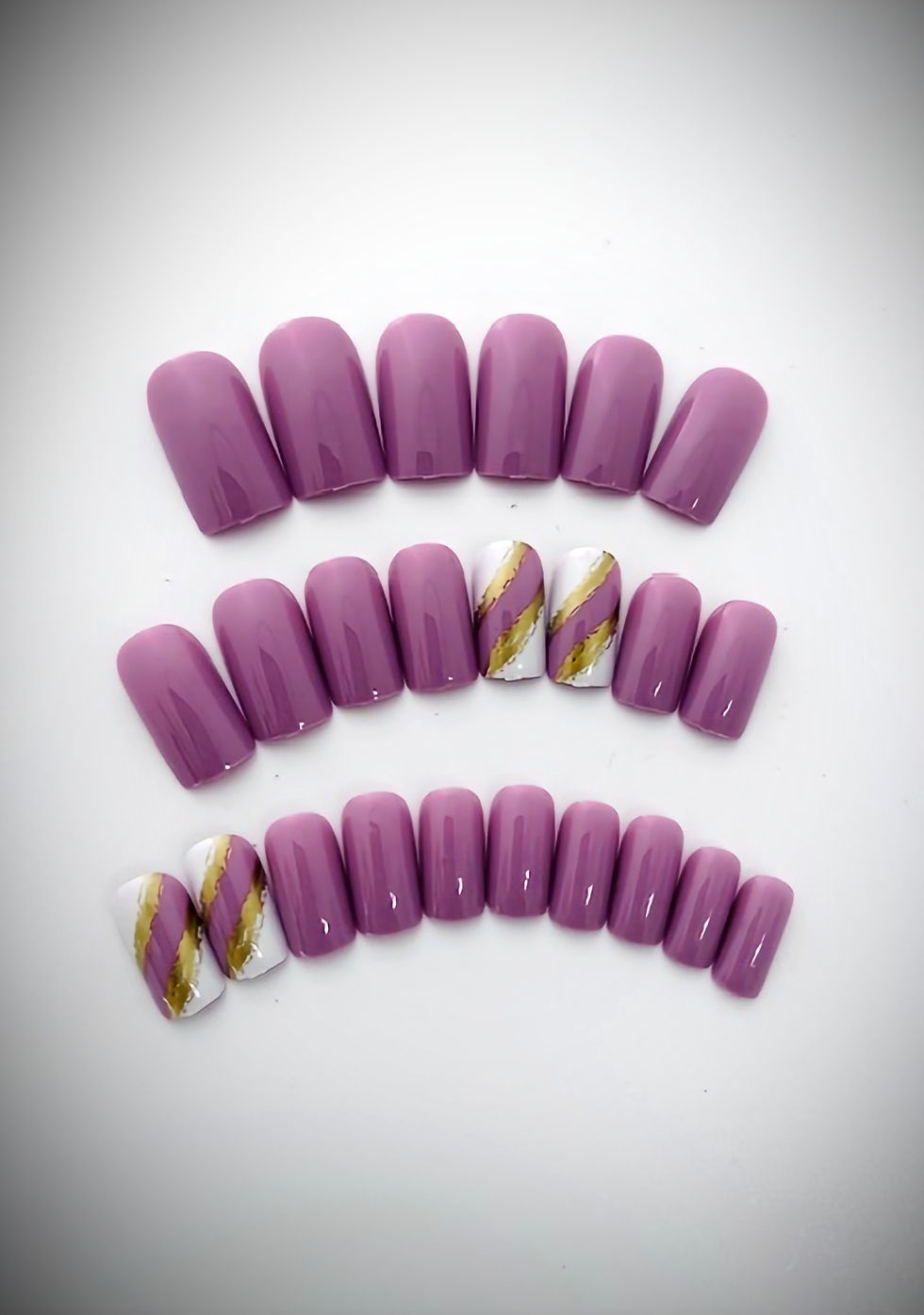 The Leslie design is a mulberry purple set with a splash of white and gold on the accent nails
