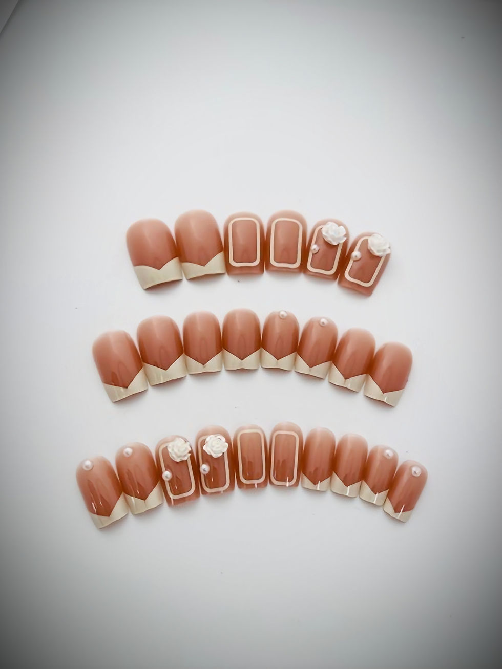 The Luella design is a soft brown and cream color accented French Tip design with 3D Flowers