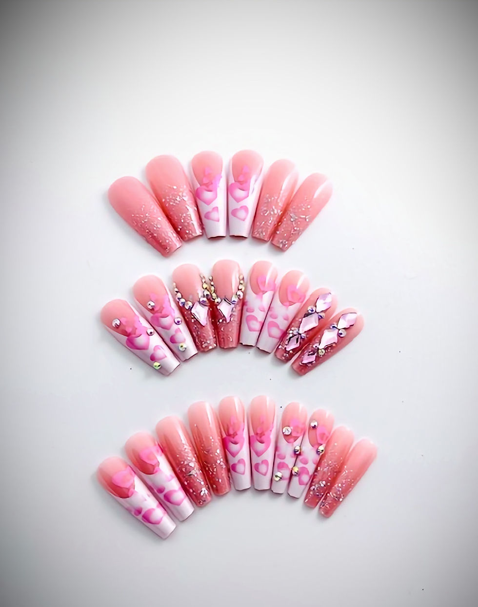 The Cassie set features French tips decorated with bubblegum pink floating hearts and rhinestones