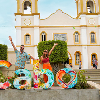 Couple posing by the letters of San Jose del Cabo in front of the Mission in San Jose del Cabo, Mexico.