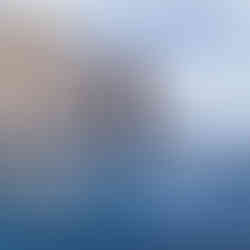 Two divers on the edge of the catamaran about to dive into the water by the Arch of Cabo, Mexico.