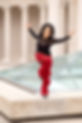 Frances Teves Sedayao, a Filipina American dancer wearing a black top and red cargo pants, balancing on one foot outside in the Court of Honor at Legion of Honor Museum