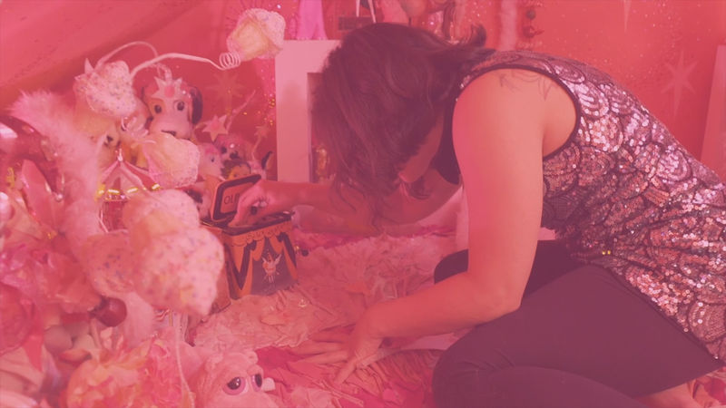 Megan Lowe interacting with items in a pink room.