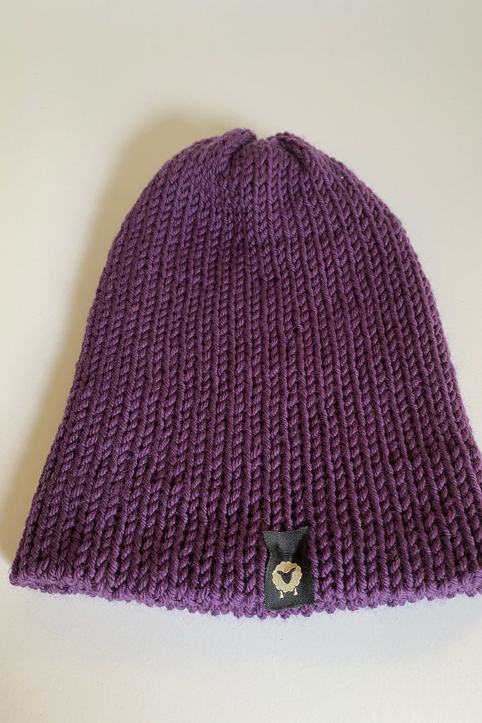 Thumbnail: Close-up of the purple merino beanie showing wool knit texture and stitching detail.”