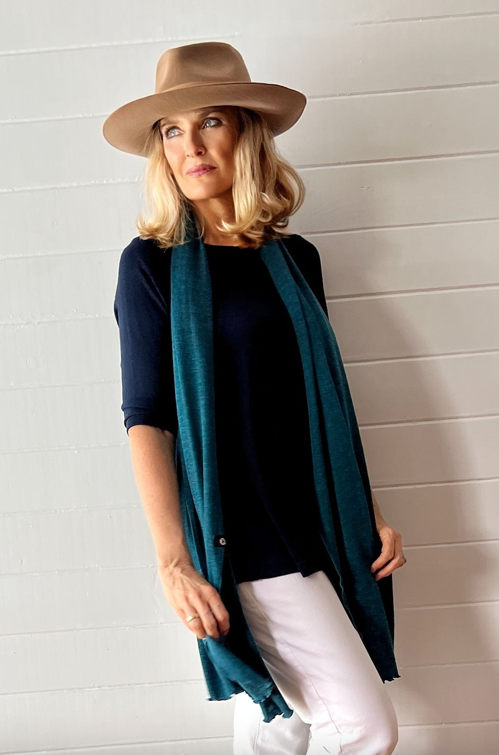 Thumbnail: Woman wearing the teal marl Merino Travel Wrap and Scarf in a relaxed lifestyle pose.