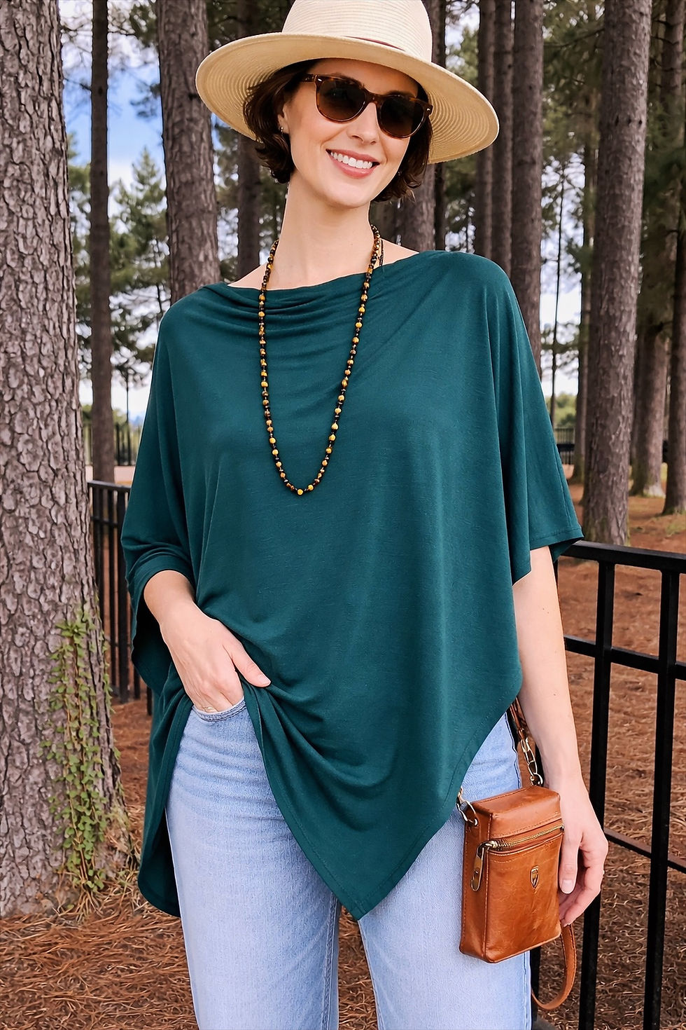 Woman wearing the deep teal green Merino Wool Poncho in a relaxed lifestyle pose.