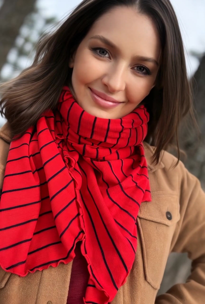 Thumbnail: Video of model wearing the lava red striped Merino Travel Wrap and Scarf, showing the movement of the merino fabric.