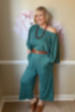 Model wearing the Sierra dusty teal merino jumpsuit in a off shoulder lifestyle pose.