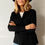 Thumbnail: Woman wearing the merino wool Jesse cardigan in black, front view showing fit and drape.