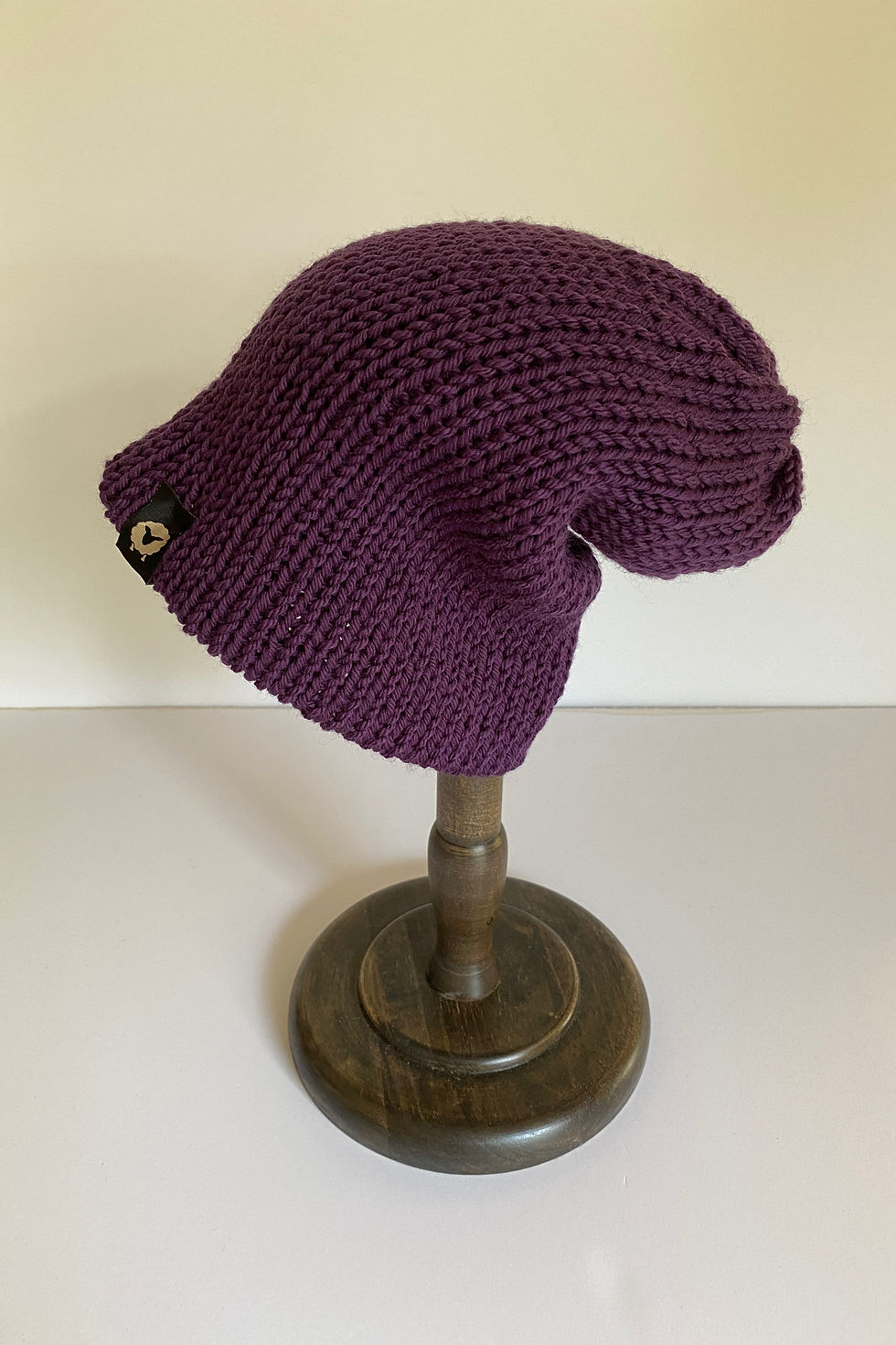 Thumbnail: Purple merino beanie shown folded, highlighting shape and knit texture.