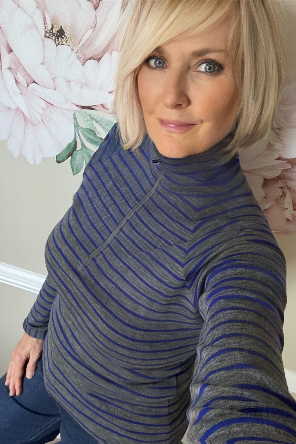Woman wearing the grey striped Hayden rib merino zip-neck top in a relaxed lifestyle pose.