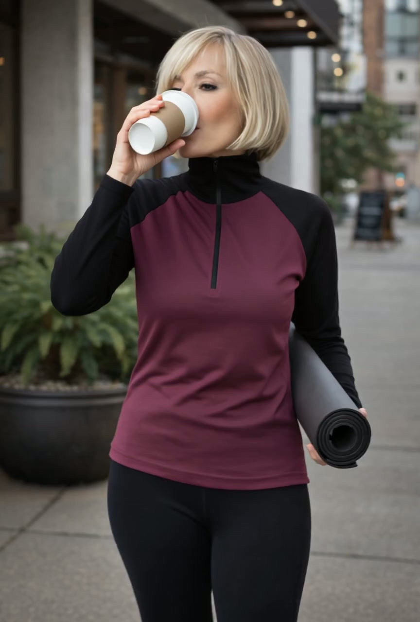 Thumbnail: Video of model wearing the black mulberry Riley zip-neck top, showing the movement and drape of the mid-weight merino jersey