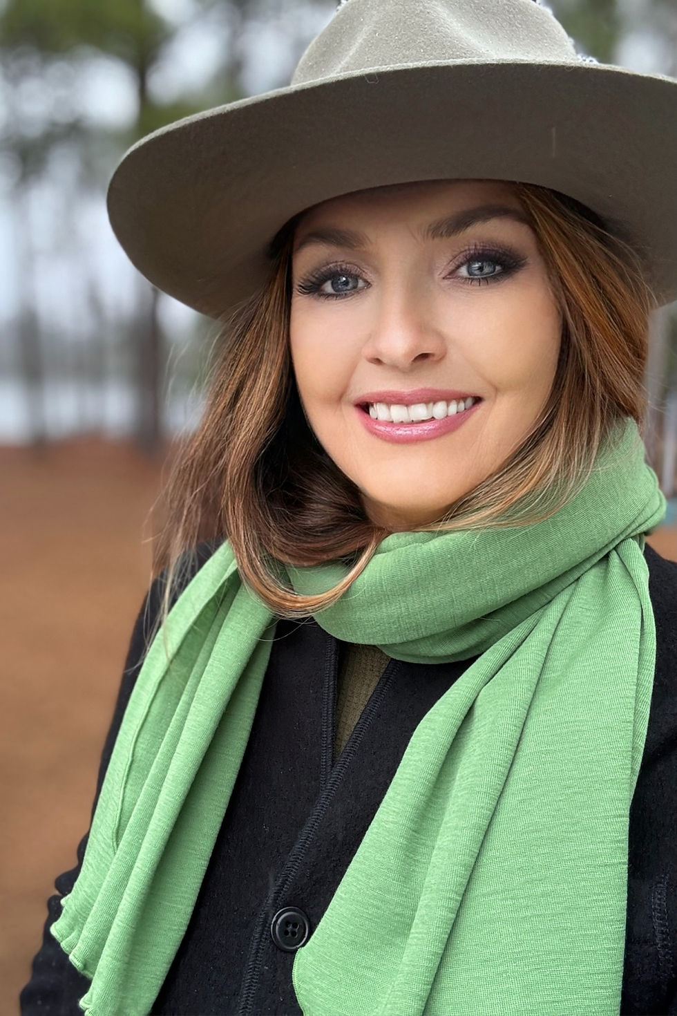 Thumbnail: Woman wearing the apple green Merino Travel Wrap and Scarf in a relaxed lifestyle pose.