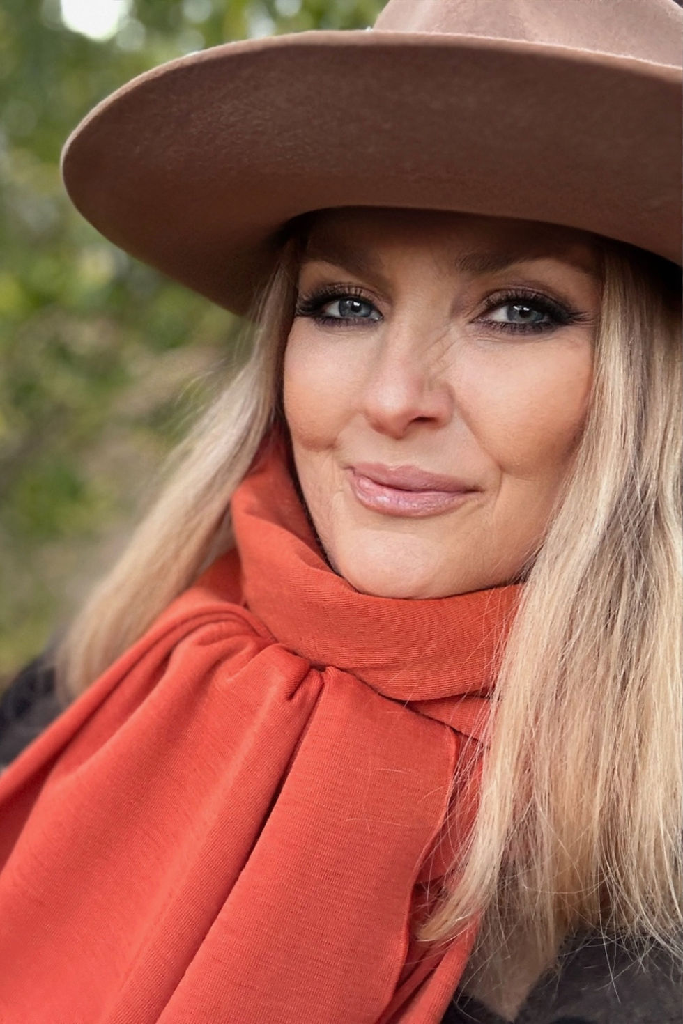 Thumbnail: Close-up of the Merino Travel Wrap and Scarf in saffron orange showing mid-weight rib merino fabric and texture.