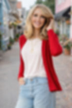 Model wearing the Jesse cardigan in Coral mid-weight rib merino wool, full-body lifestyle pose.