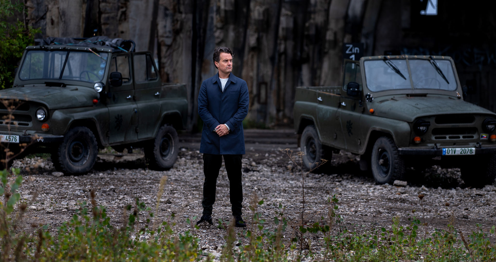 Man standing between military vehicles Wie is the Mol?