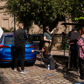 Film crew shoots scene with blue Skoda car