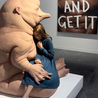 A hyperrealistic sculpture displayed at Art Basel Miami — a seated humanoid figure with exaggerated