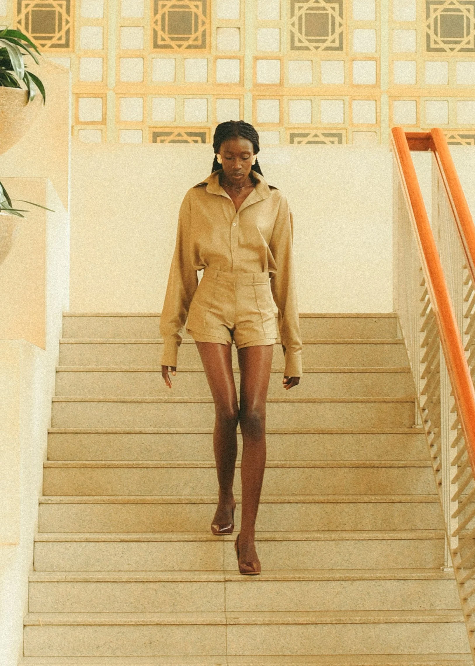 Effortless Movement” — A model strides in a light cotton dress down a stairwell, marrying elegance a