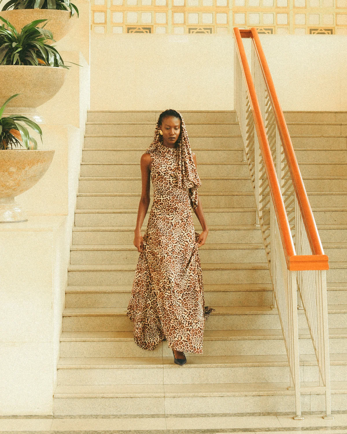 Effortless Movement” — A model strides in a light cotton dress down a stairwell, marrying elegance a