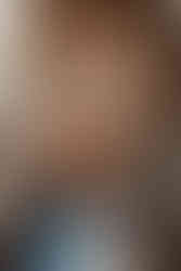 Eine Schwangere und ihr Mann liegen ihre Händen auf ihrem nackten Bauch bei einem Fotoshooting in Stuttgart