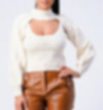 Woman posing in cream sweater.