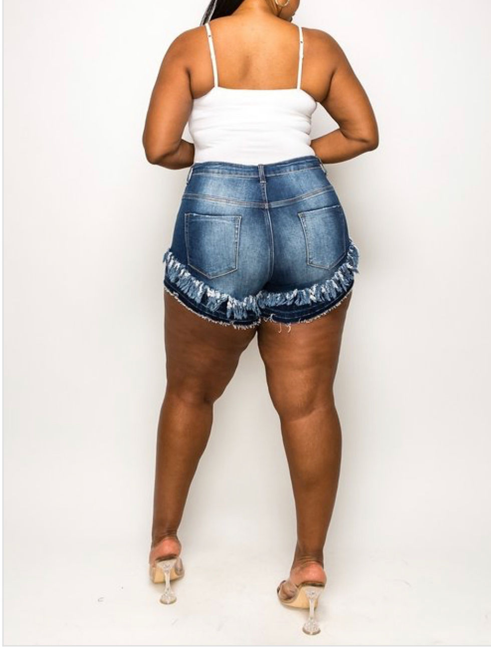 Thumbnail: Woman in denim shorts showing back of shorts.