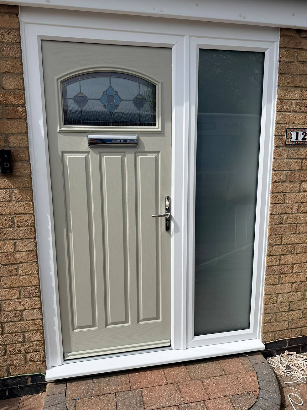 Light green composite front door with arched decorative stained-glass window, chrome hardware, and full-length frosted sidelight set in a light brown brick wall
