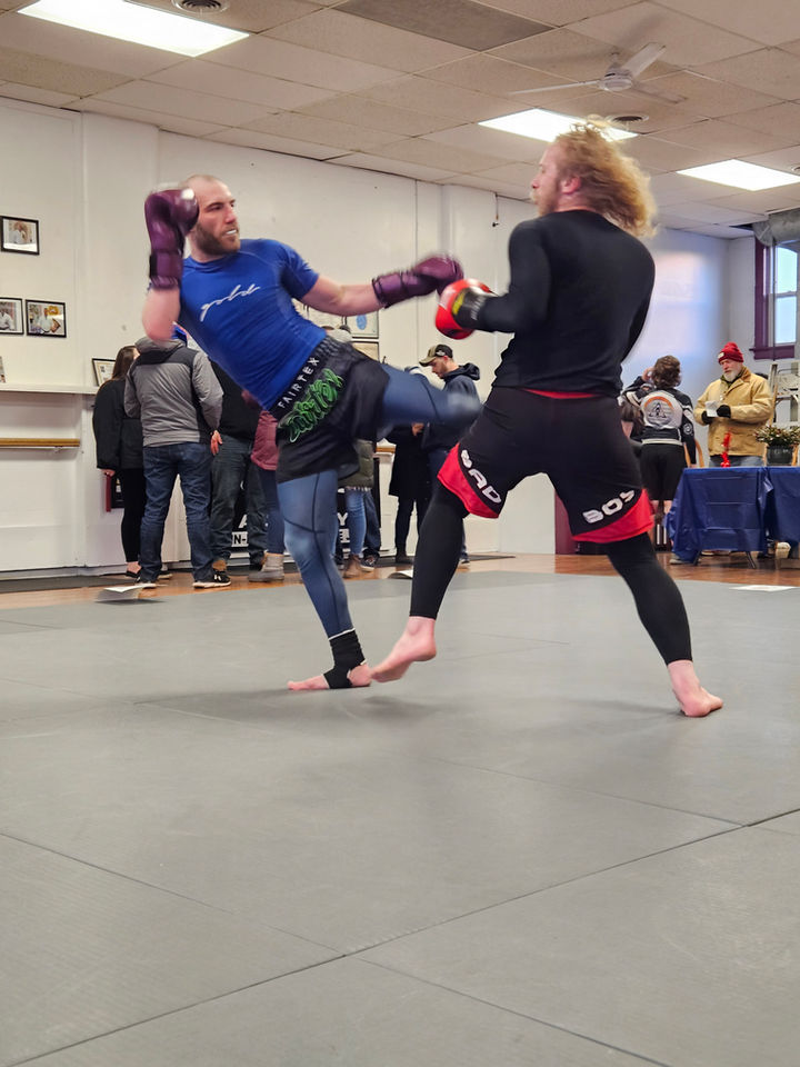 striking mma class two members sparring each going for a kick