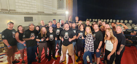 wide angle group photo with black branded shirts on