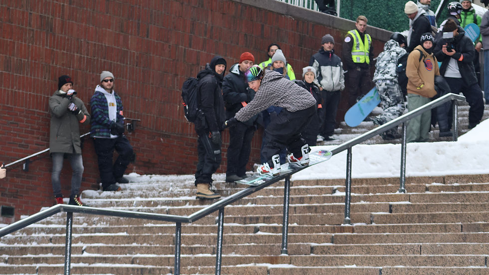 Olympic snowboarder Jess P. from Vermont showcases her skills on a snowy staircase rail in Boston during the Heavy Metal event.