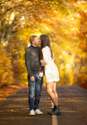 Couple shares an intimate moment in the autumn leaves of the Pentlands, Edinburgh, showcasing the warm colors and natural beauty of the season.