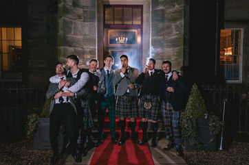 Groomsmen smoking cigars in editorial style photo featured in vogue magazine. Smoke and lights used for dramatic effect.