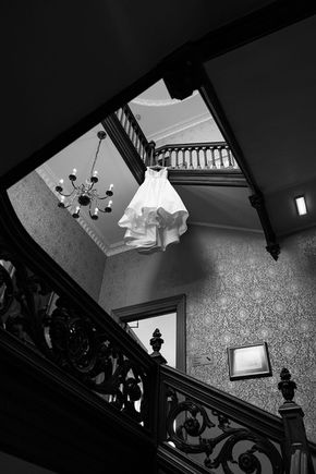 Top-down view of the bride’s wedding dress, elegantly displayed on a decorative surface, showcasing the delicate lace and intricate details.