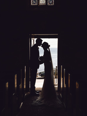 Bride and groom kiss in the Wilson Memorial Chapel in Maine.
