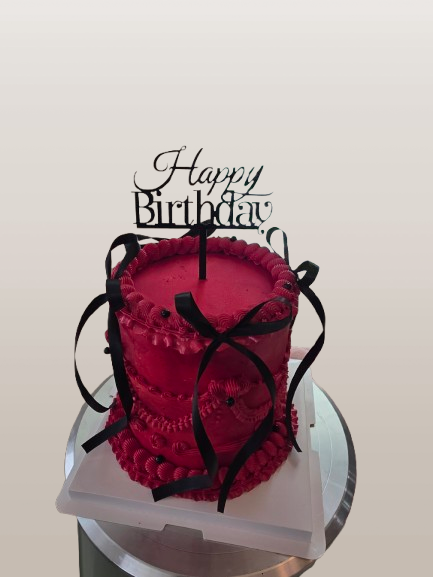 Thumbnail: Red birthday cake with black ribbons and 'Happy Birthday' topper