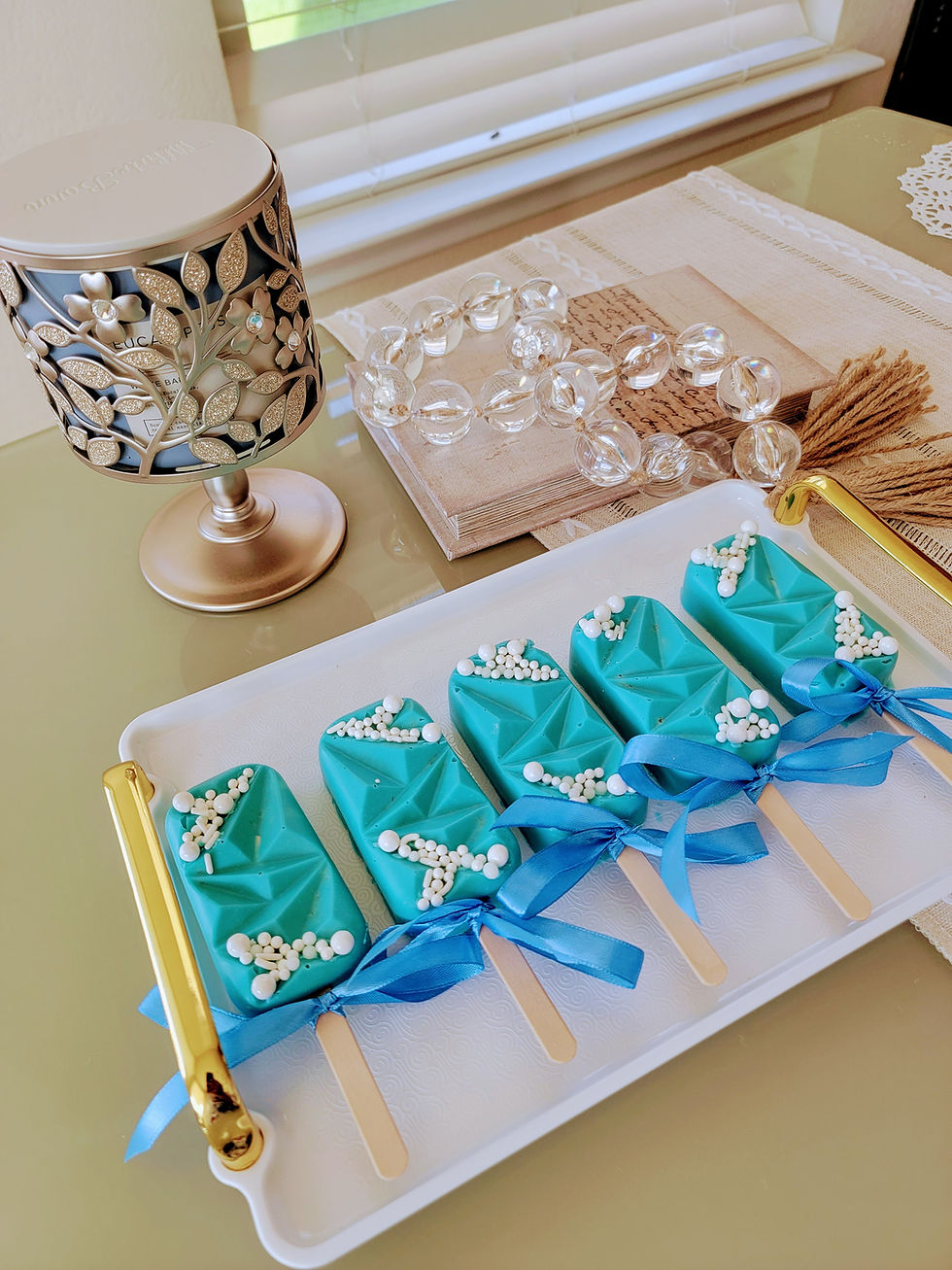 Thumbnail: Teal dessert pops decorated with white pearls and blue ribbons