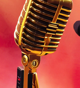 Gold and black microphone on stage under red lighting โ symbolic of spoken word and live poetry performance
