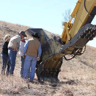 Roland showing a group of land owners an attachment for clearing cedar trees
