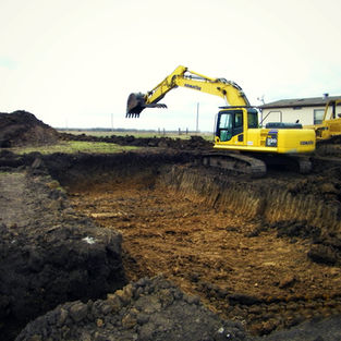 Excavator working on a road culvert installation