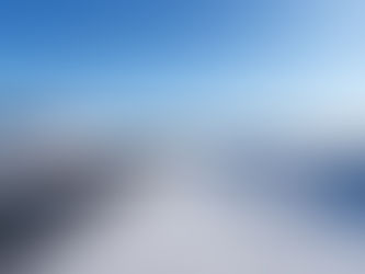 Snow-covered road leading past a building into a wide winter landscape in Kuujjuaq.