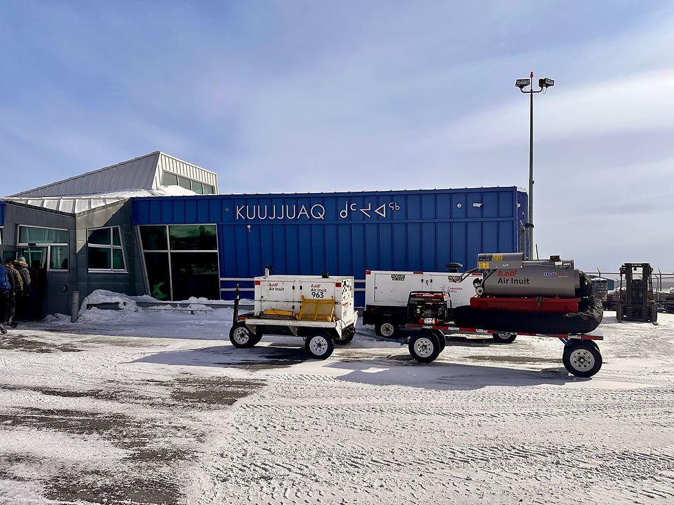 Front of the Kuujjuaq airport building with Inuktitut syllabics, a snow-covered tarmac, and Air Inuit equipment.