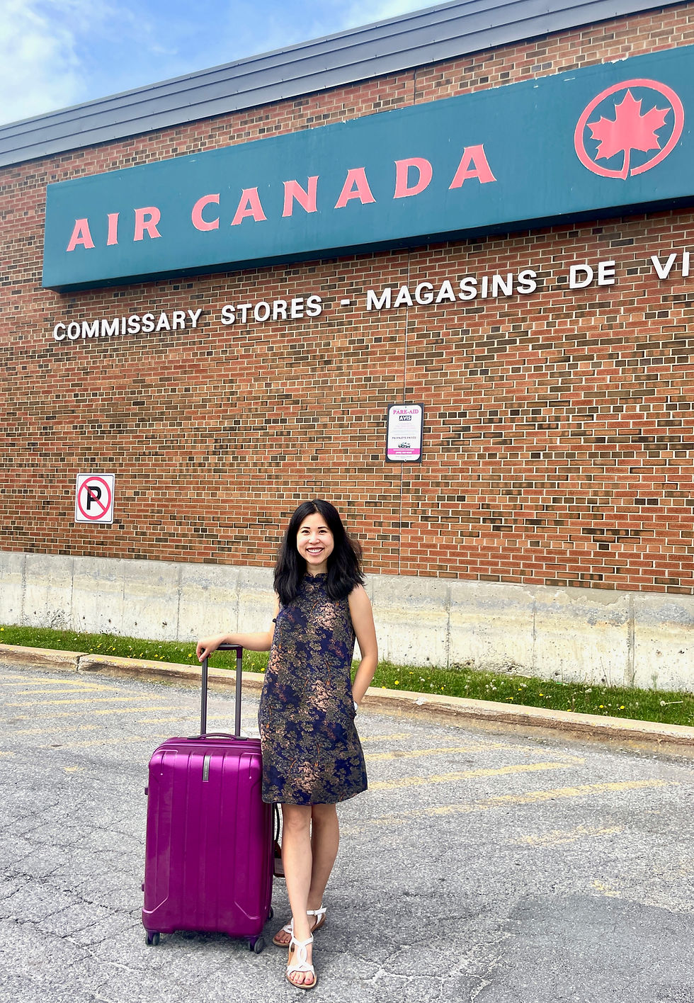 Dr. Michelle Kwok standing with a magenta suitcase outside the Air Canada commissary after retrieving lost luggage